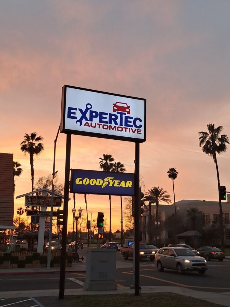 Expertec Automotive and Good Year signs at sunset