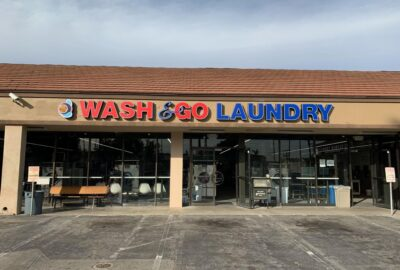 View of blue and red exterior signage for Wash & Go Laundry