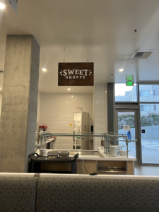 a hanging brown sign reading sweet shoppe