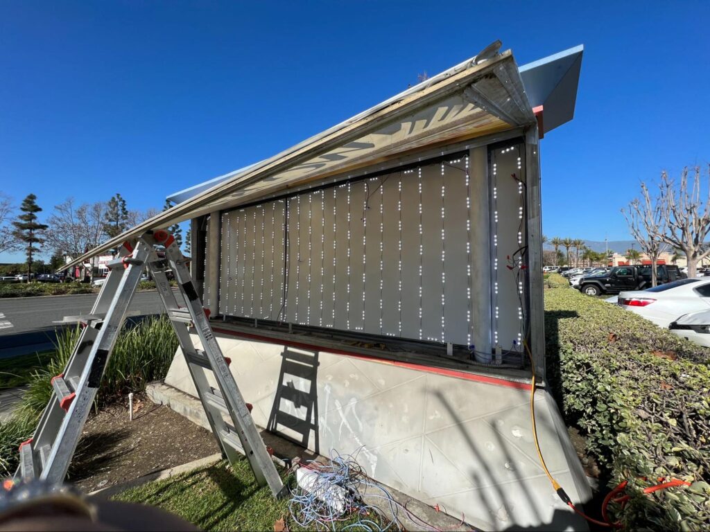 Photo showing the interior of a lighted monument sign being serviced.