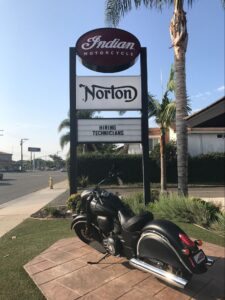 a twin-pole mounted pylon sign advertising Norton and Indian Motorcycles