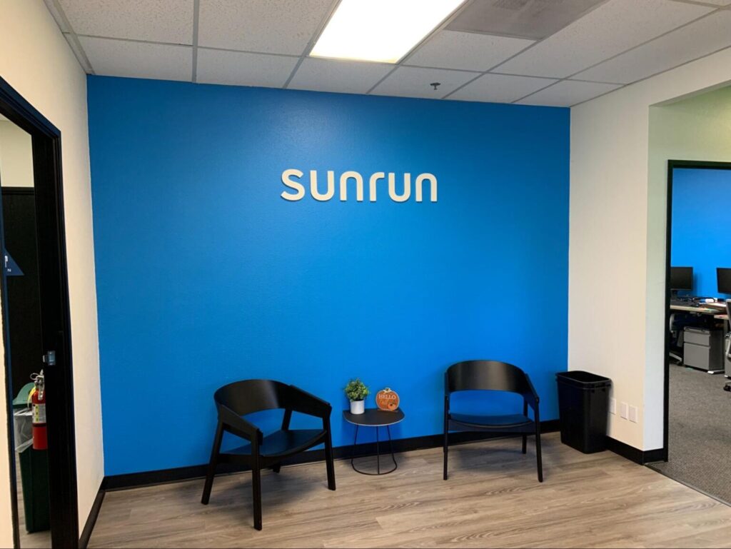 a white SUNRUN interior sign on a blue wall