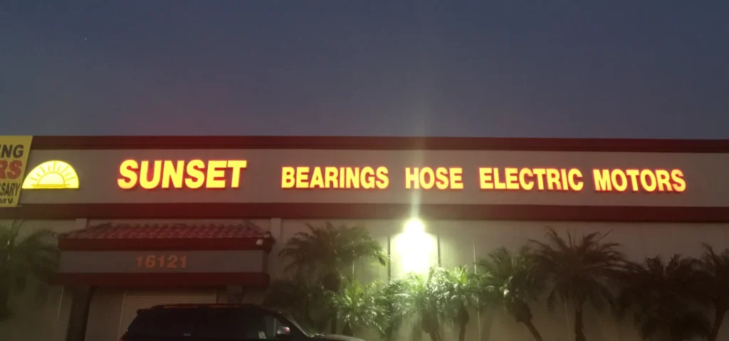 Channel letter sign illuminated at dusk.