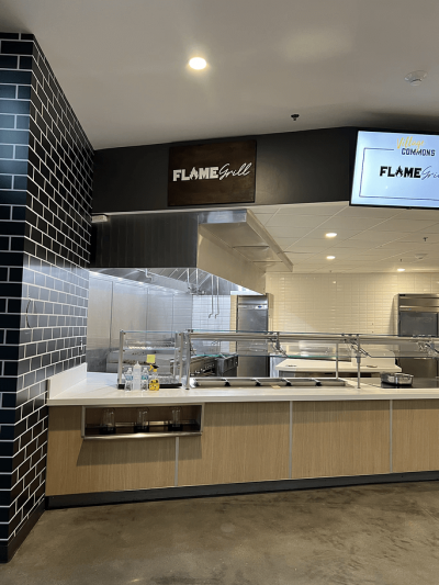 a mounted sign in a kitchen area reading Flame Grill