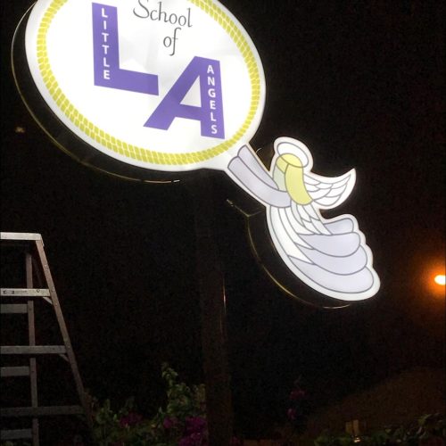 a lighted pylon sign advertising the School of LA