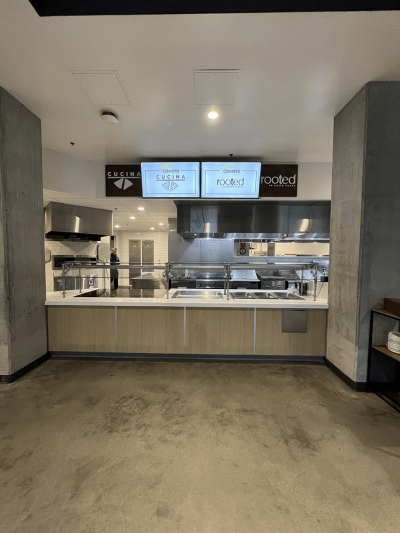 two mounted signs on either side of two screens in a food court kitchen area