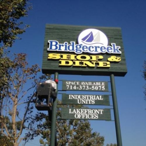 a twin-pole mount pylon sign advertising Bridgecreek Shop & Dine.